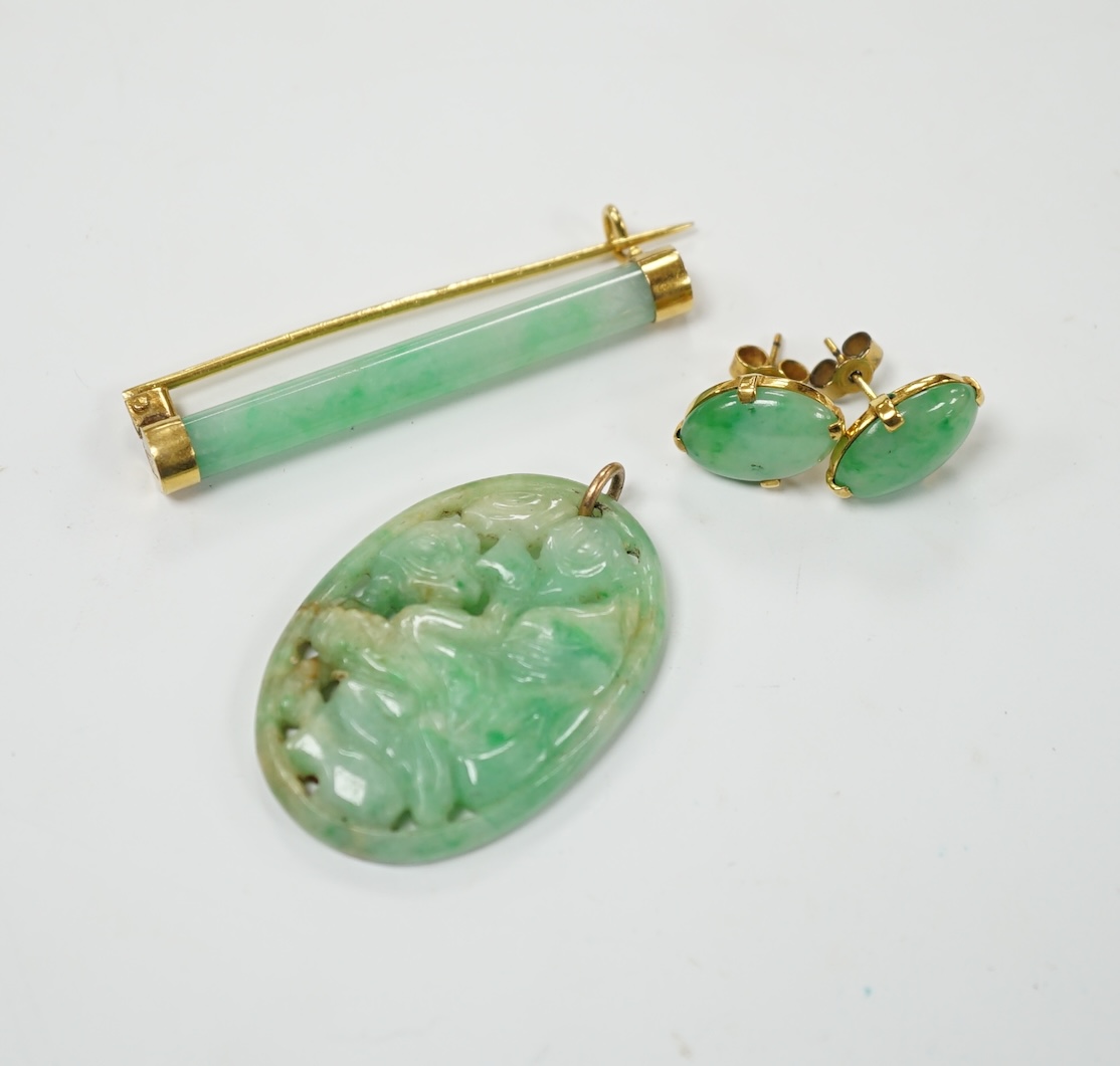 A Chinese yellow metal(stamped 18) mounted jade bar brooch, 48mm, a carved jade pendant and a pair of yellow metal mounted oval jade earrings, gross weight 19.9 grams. Fair to good condition.